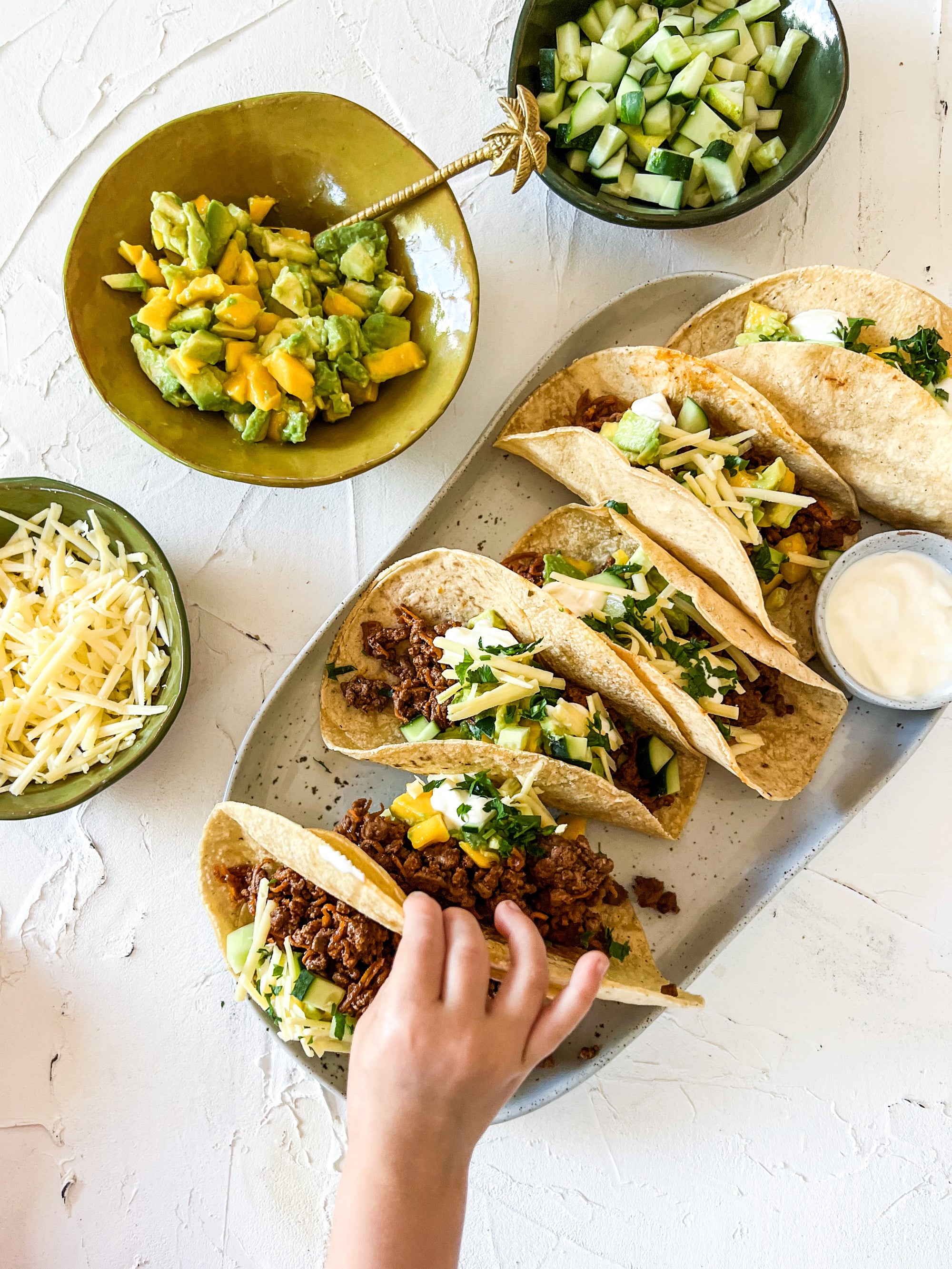 Quick kid-friendly beef tacos with avo mango salsa, yoghurt and shredded cheese