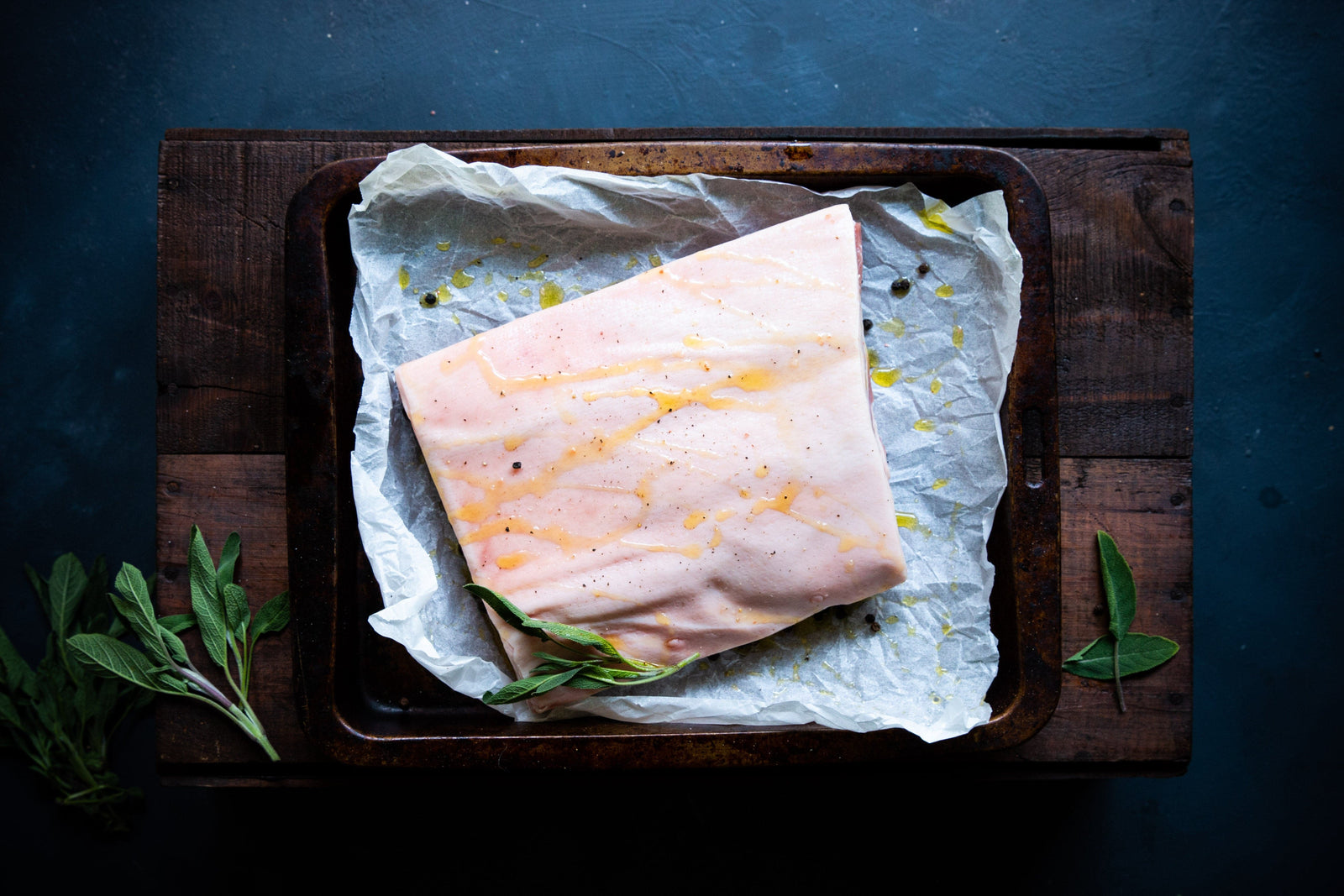  A great pork belly cut in a roasting tray with olive oil and seasoning on the skin